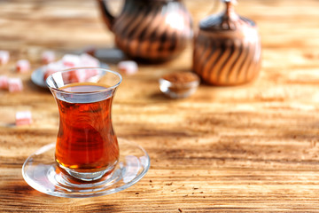 Turkish tea in traditional glass on wooden table closeup