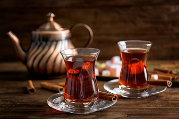 Türkischer Tee im traditionellen Glas auf Holztischnahaufnahme