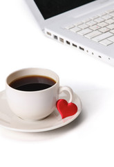 Laptop or notebook with cup of coffee and heart on table