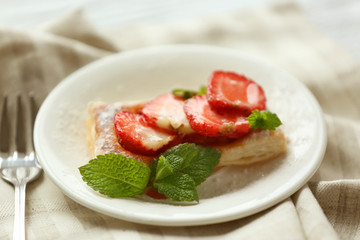 Sweet tasty pastry with strawberries on plate, closeup