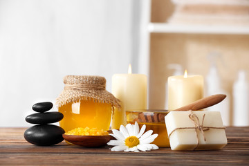 Fototapeta na wymiar Spa concept. Honey treatments, candles and pebbles on wooden table