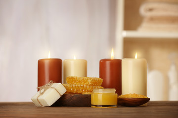 Fototapeta na wymiar Spa concept. Beautiful composition of alight candles and natural honey treatments on wooden table