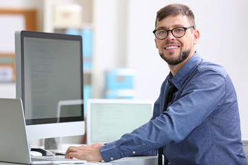 Handsome young programmer working in office