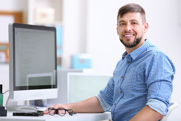 Handsome young programmer working in office