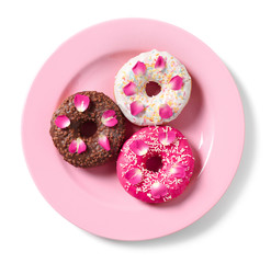 Plate with delicious doughnuts and beautiful flowers on white background