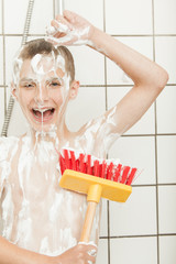 Happy child covered in soap with large scrub brush