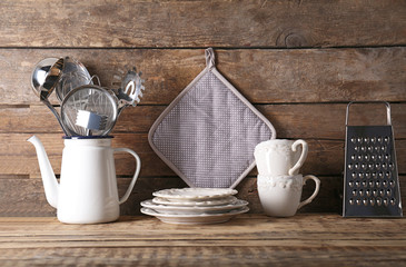 Cooking utensils and dishware on wooden background