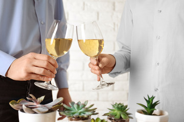 People toasting with glasses of white wine, closeup