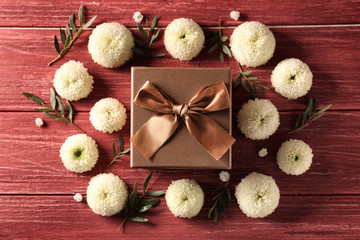 Gift box with flowers on wooden background