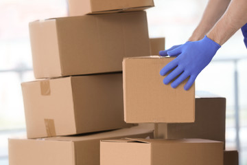 Delivery man moving boxes indoors