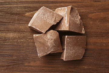 Chocolate pieces on wooden background