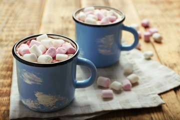 Cups of hot cocoa with marshmallows on napkin
