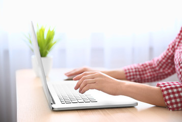 Fototapeta na wymiar Closeup of woman working on laptop