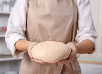 Obraz na płótnie Canvas Closeup of woman holding raw dough