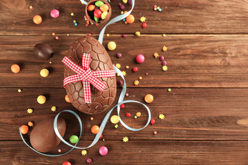 Easter composition with chocolate eggs on wooden background