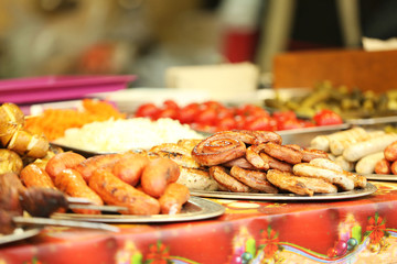 Tray with different kinds of sausages on counter