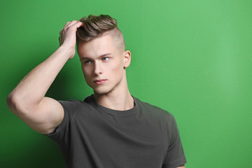 Handsome young man posing on color background