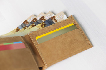 Canadian Dollars and credit cards in mustard coloured leather wallet