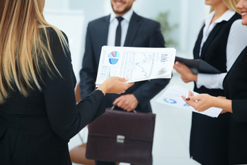 business team with financial documents greets her boss in the of