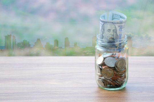 Dollar coin and banknote cash saving in glass jar, with city building background, finance saving concept
