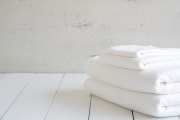 Fototapeta na wymiar White cotton towels use in spa bathroom on wood background.