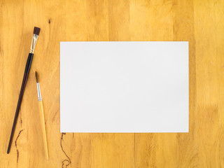 White paper with paintbrush on wood background, Blank paper