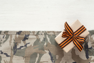 Gift box with st george ribbons on the khaki background. Defende