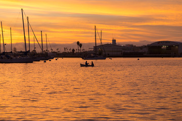Pink, yellow, red, orange sunset sky in California, San Diego. Sailboats, boats. Silhouette