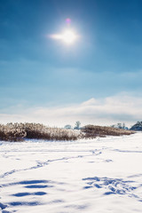 Landscape in winter on the lake covered with snow