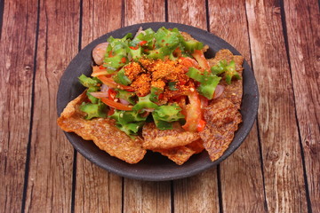Spicy sour wing bean salad  with crispy pork served .