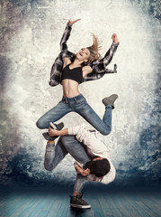 Fototapeta premium Couple break dancing on wall background