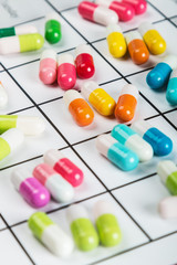 Naklejka na ściany i meble different color tablets and pills on a calendar medication.