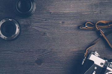 Old camera and lenses on dark wooden background