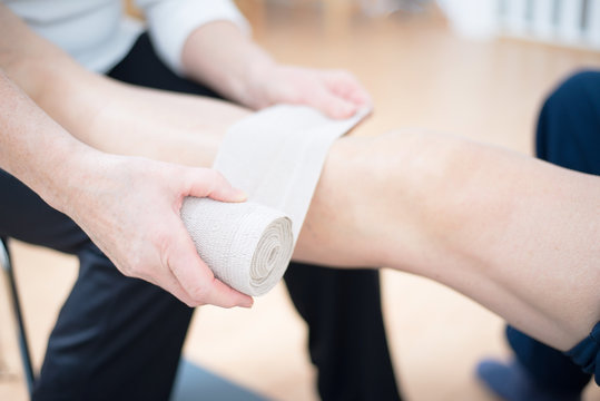 Binde wird um das Knie gewickelt