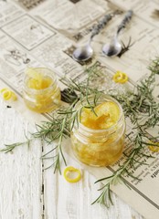 orange marmalade in small glass jars with rosemary, selective focus