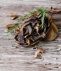 jerked meat, cow, deer, wild beast or biltong in wooden bowls on a rustic table