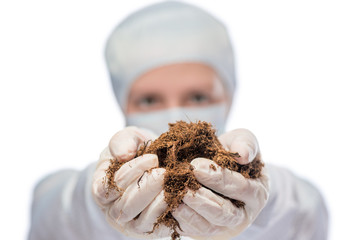 Specialist biologist holds a soil sample, hand in the focus clos