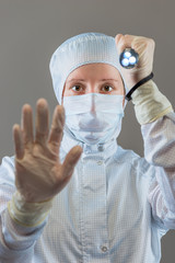 chemist with a flashlight shows STOP gesture hand on a gray back