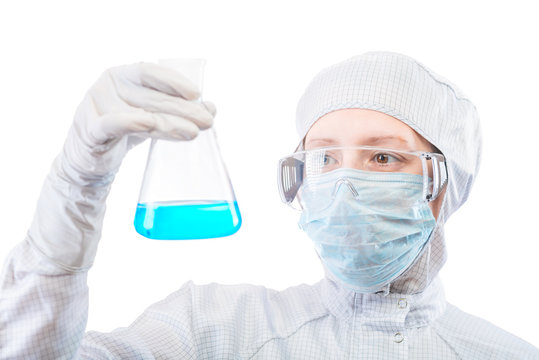 female researcher analyzing a liquid blue substance in a flask