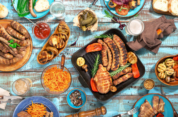 Variety of food grilled on wooden table, top view