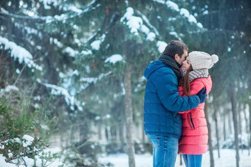 woman and man having fun in winter forest