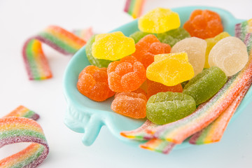 Candy background. Colorful candies in plate on light background