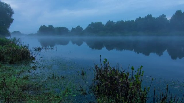 Foggy Landscape time lapse of sunrise over water of Desna river in Ukraine.
