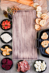 Bruschetta ingredients around wooden board. Top view. Copy space, frame.