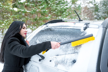 Woman cleaning car windshield of snow winter happy young scraper