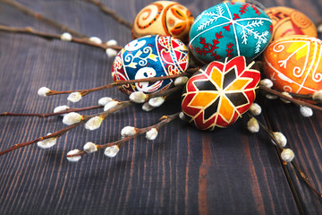 Easter eggs with willow twigs on a wooden plank table.