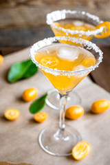 cocktail with kumquat on wooden background