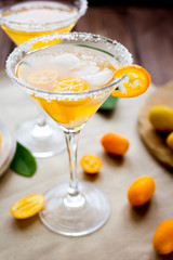cocktail with kumquat on wooden background