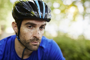 Mud spattered man in cycling helmet