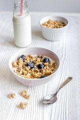 Homemade fitness granola with yoghurt and berries on white kitchen background